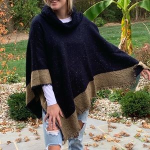 Blue poncho with tan trim and loose turtleneck